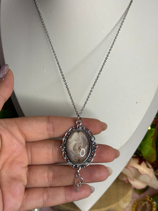 Aureole Keepsake Necklace shown in hand for scale
