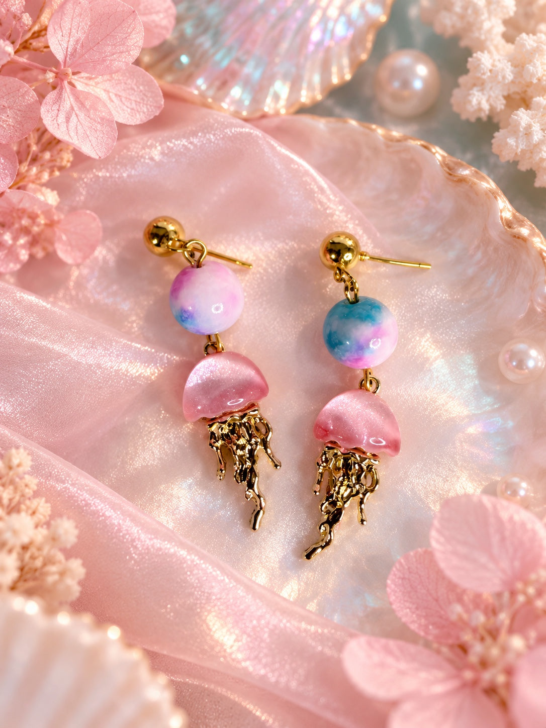 Gold-tone stud earrings with pastel pink and blue round beads and pink jellyfish charms with dangling gold-tone tentacles