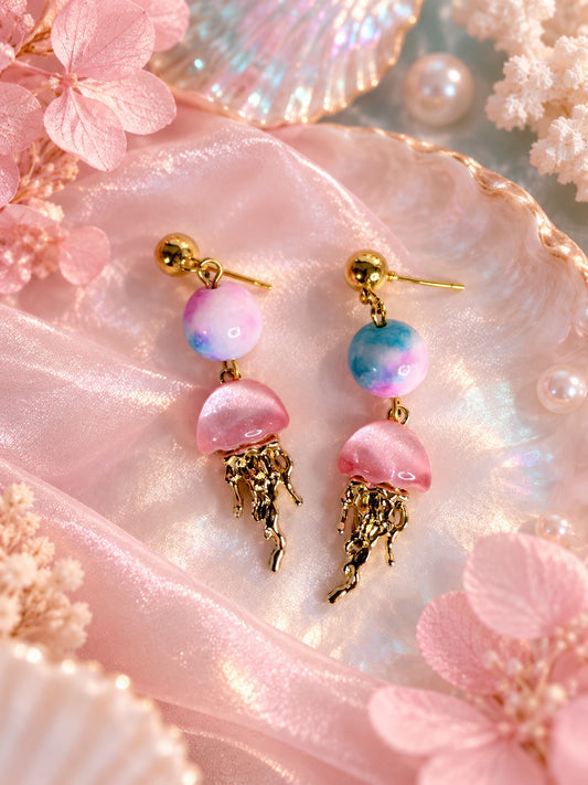 Gold-tone stud earrings with pastel pink and blue round beads and pink jellyfish charms with dangling gold-tone tentacles