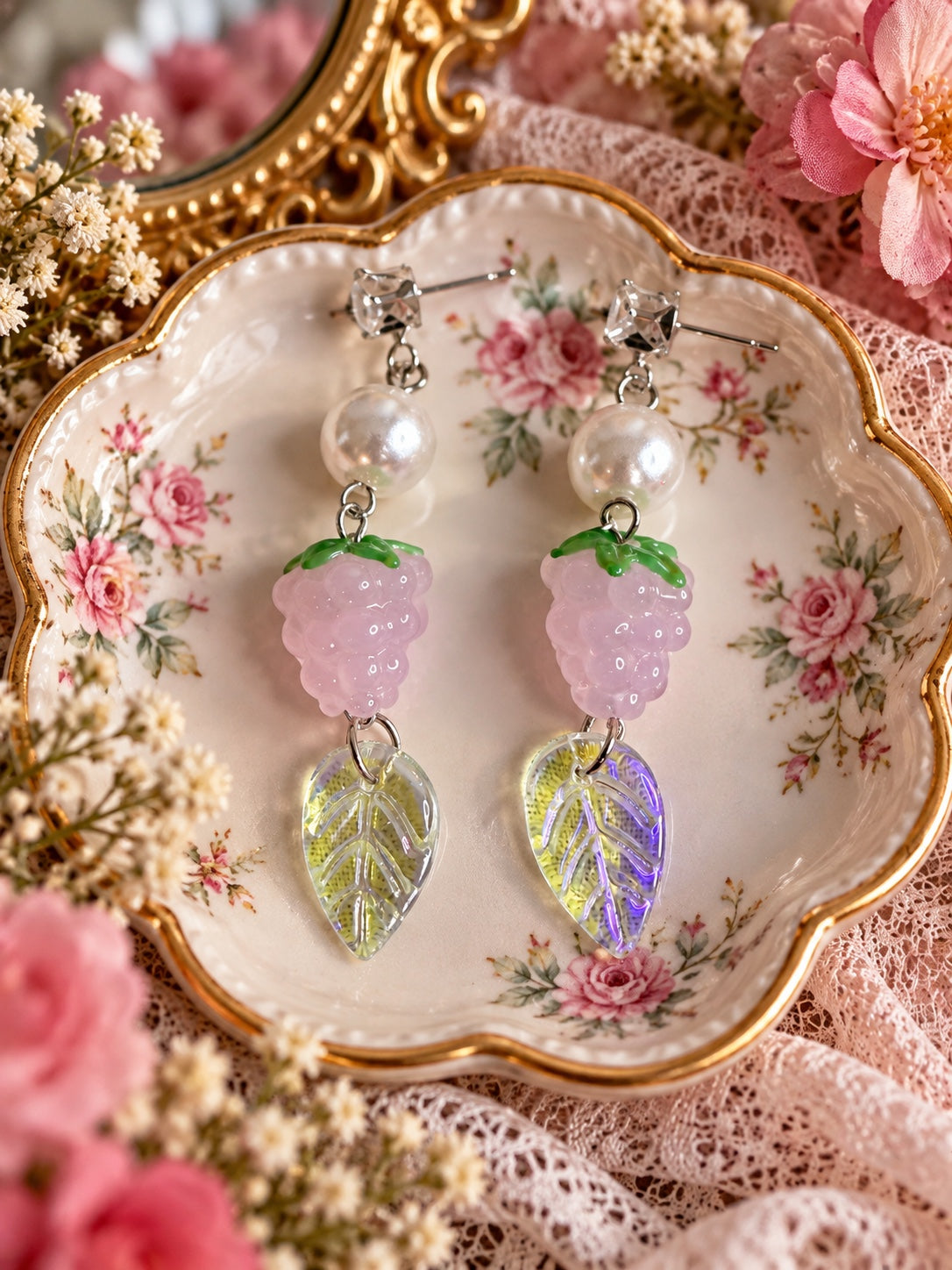 Silver-tone stud earrings with clear square accents, white faux pearls, pink berry charms with green tops and iridescent leaf pendants
