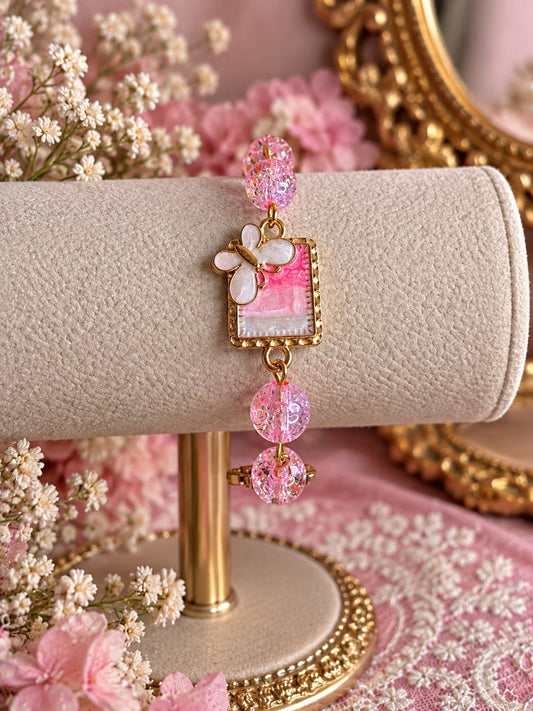 Handmade pink and gold bracelet with sparkling pink beads, floral glass centerpiece and dragonfly charm