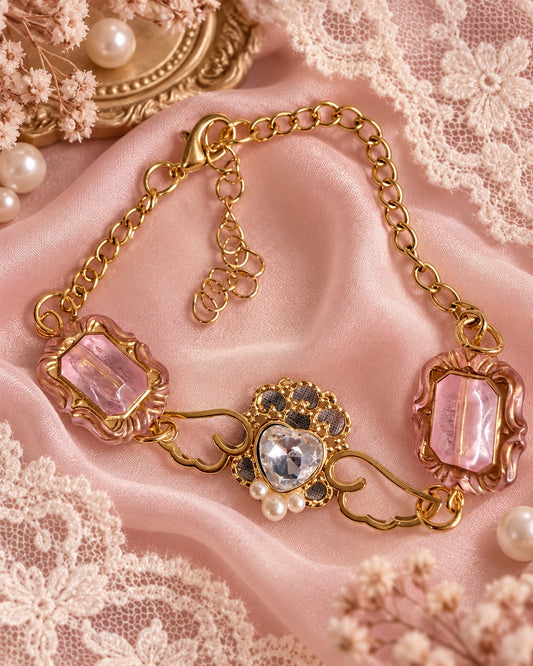 Gold-tone angel wing bracelet with a clear heart centerpiece, pearl-style accents and pink framed beads