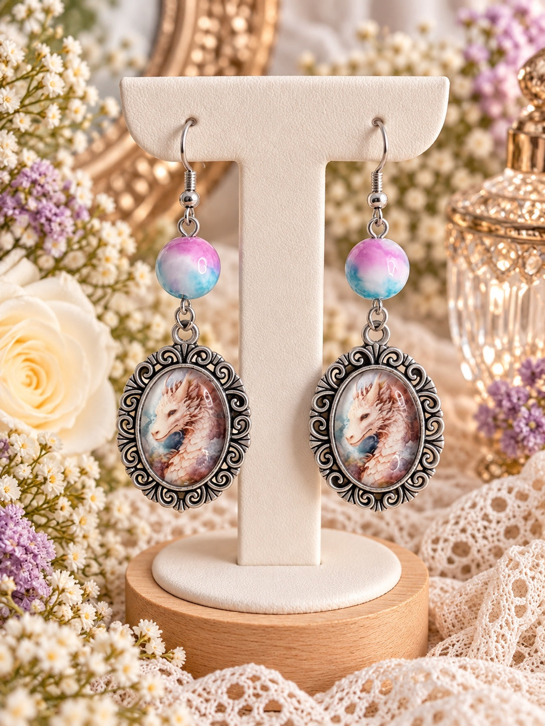 Cloudspire Dragon Earrings with pastel pink and blue beads and pale dragon portraits in ornate silver-tone oval frames