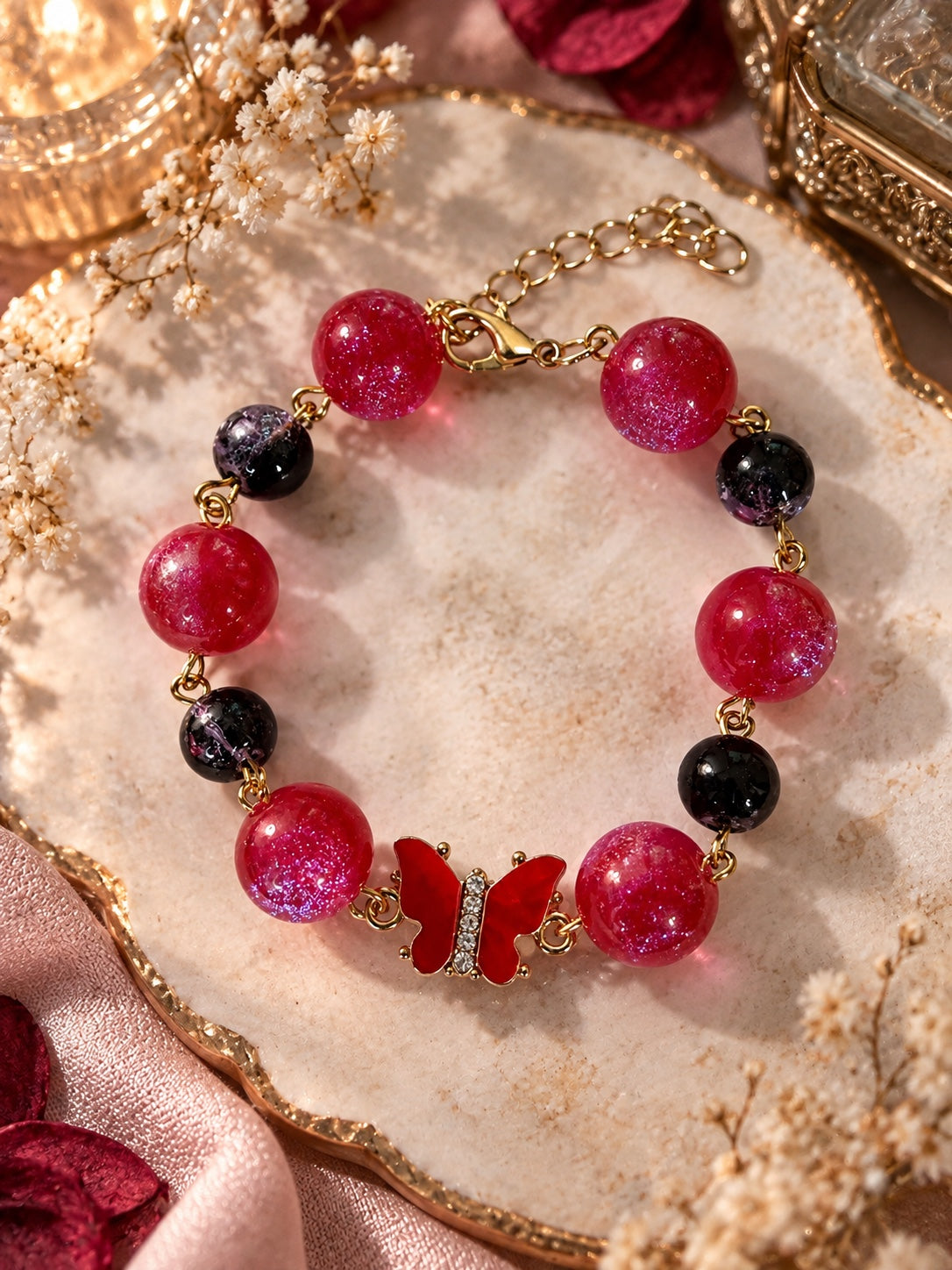 Dark fairycore bracelet with red and black beads, red butterfly centerpiece and gold-tone adjustable clasp