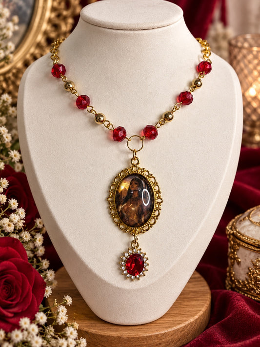 Gold-tone Egyptian goddess cameo necklace with red faceted beads and a red oval drop