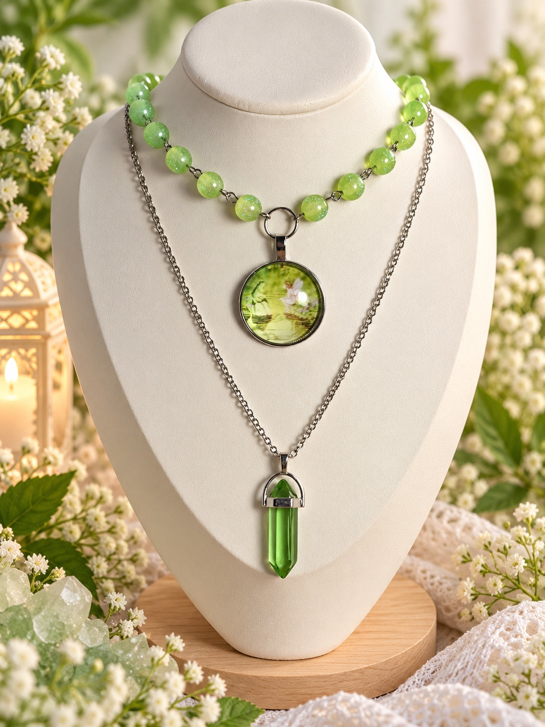 Layered silver-tone necklace with shimmering green beads, a round fairy cameo and a long green pointed pendant