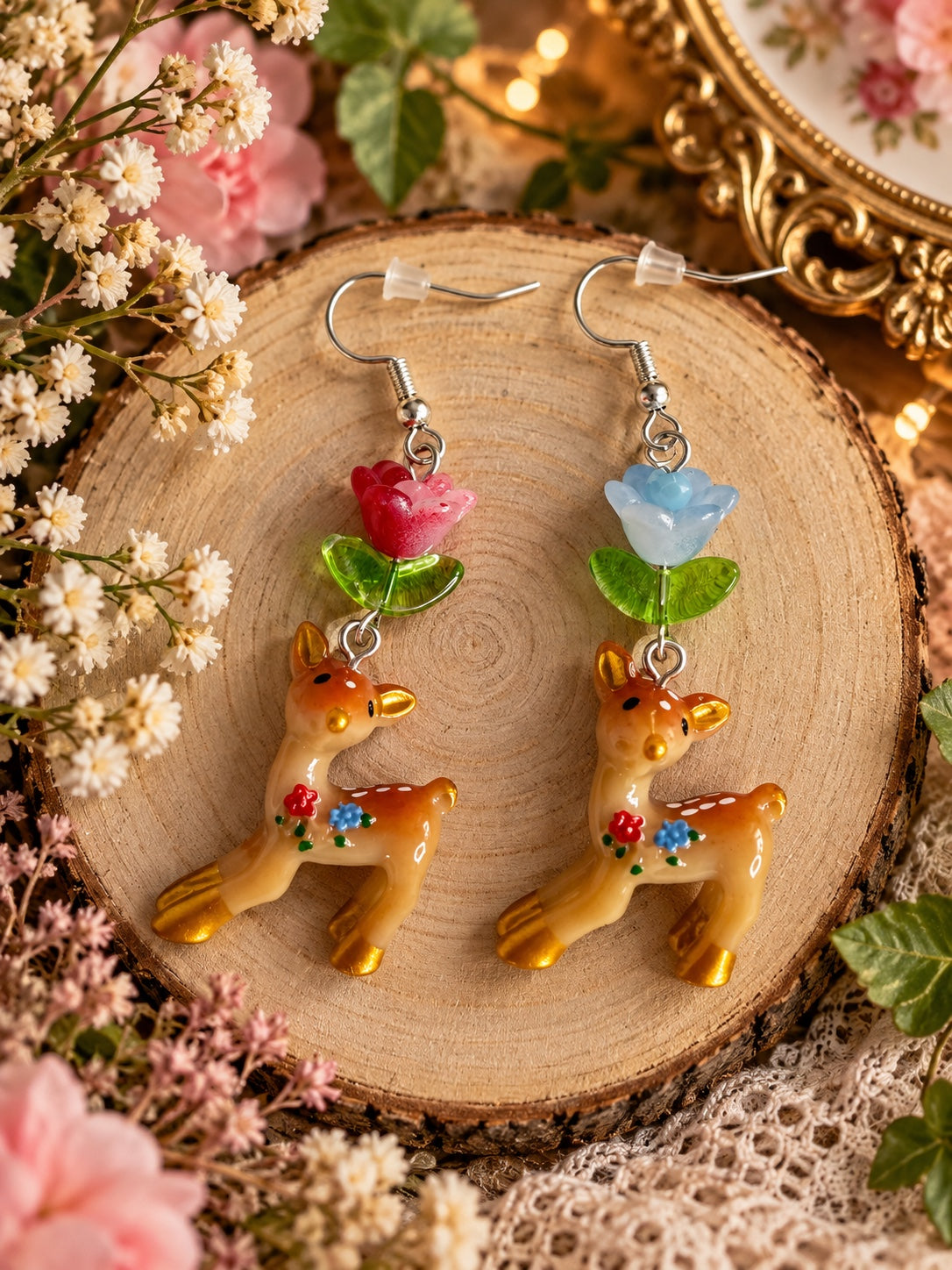 Fawn earrings with floral details, green leaves and mismatched pink and pale blue flowers on silver-tone hooks