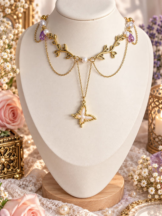 Gold-tone leafy branch necklace with white butterfly pendant, pearl accents and lavender drops