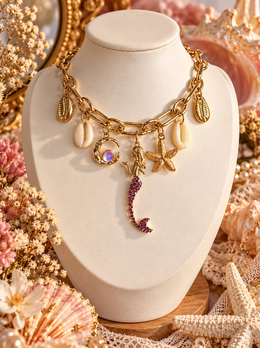 Gold-tone chunky chain necklace with a purple-tailed mermaid, crescent moon, starfish and cowrie shell charms