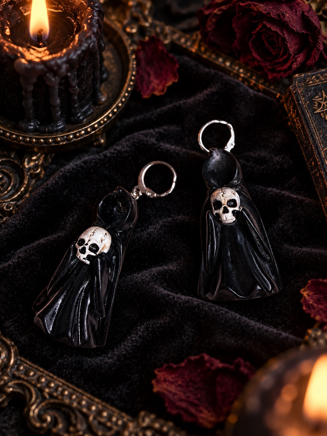 Black ghost earrings with skull faces, glossy cloaks and silver hoop findings.
