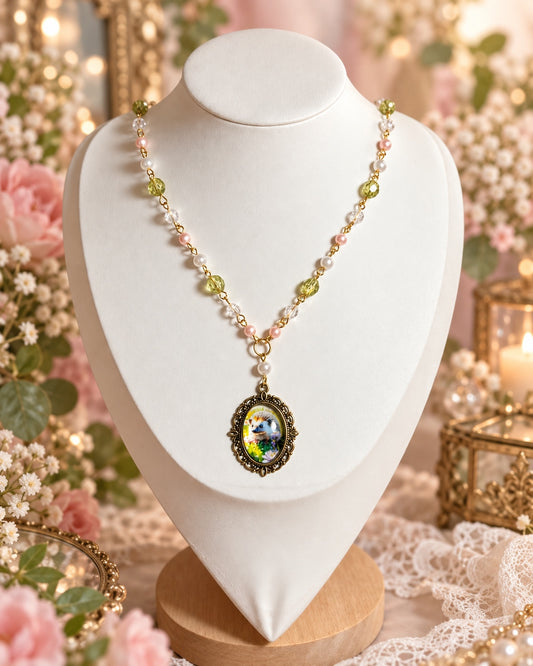Beaded necklace with green and clear beads, pink and white pearl-style accents and an oval hedgehog pendant.