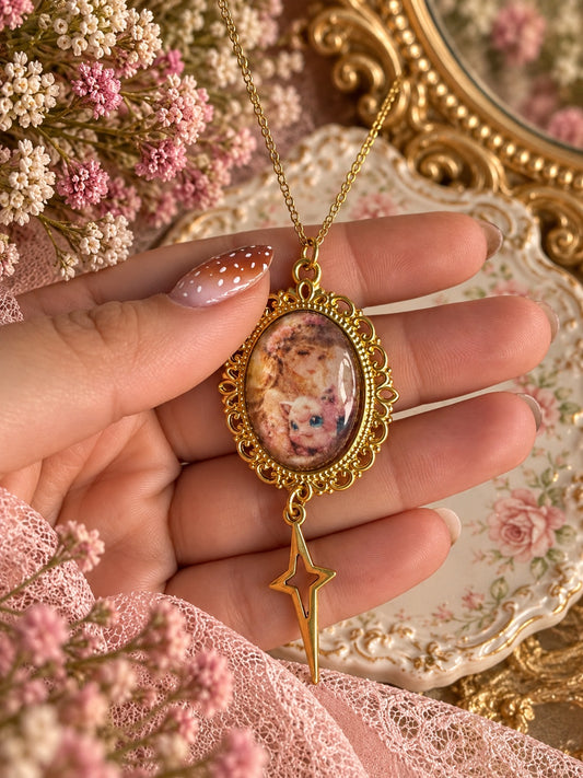 Gold-tone oval portrait necklace featuring Jigglypuff and a floral-crowned girl, with a dangling openwork star