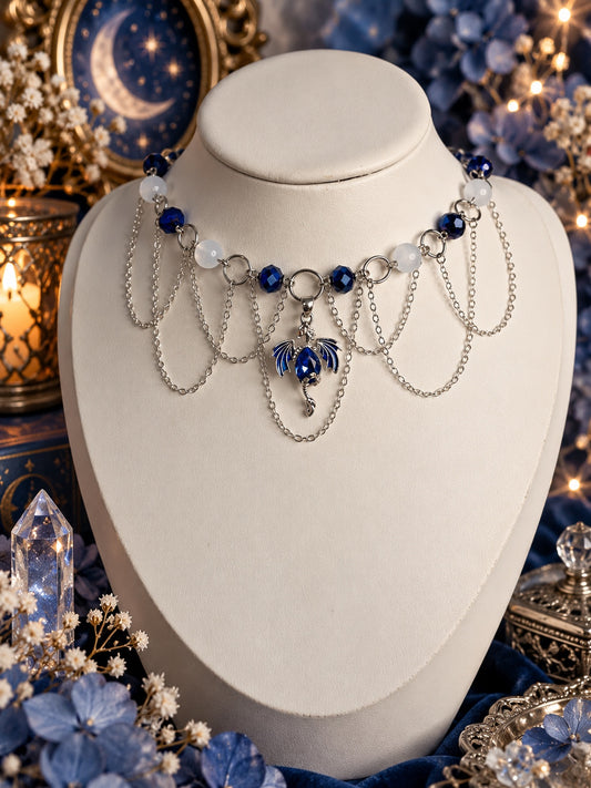 Silver-tone dragon necklace with dark blue faceted beads, milky white beads and multiple draped chains
