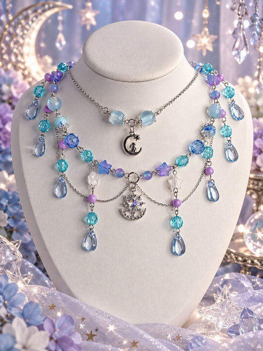 Layered celestial necklace with blue and purple beads, stars, crescent moons, a cat charm and blue teardrops