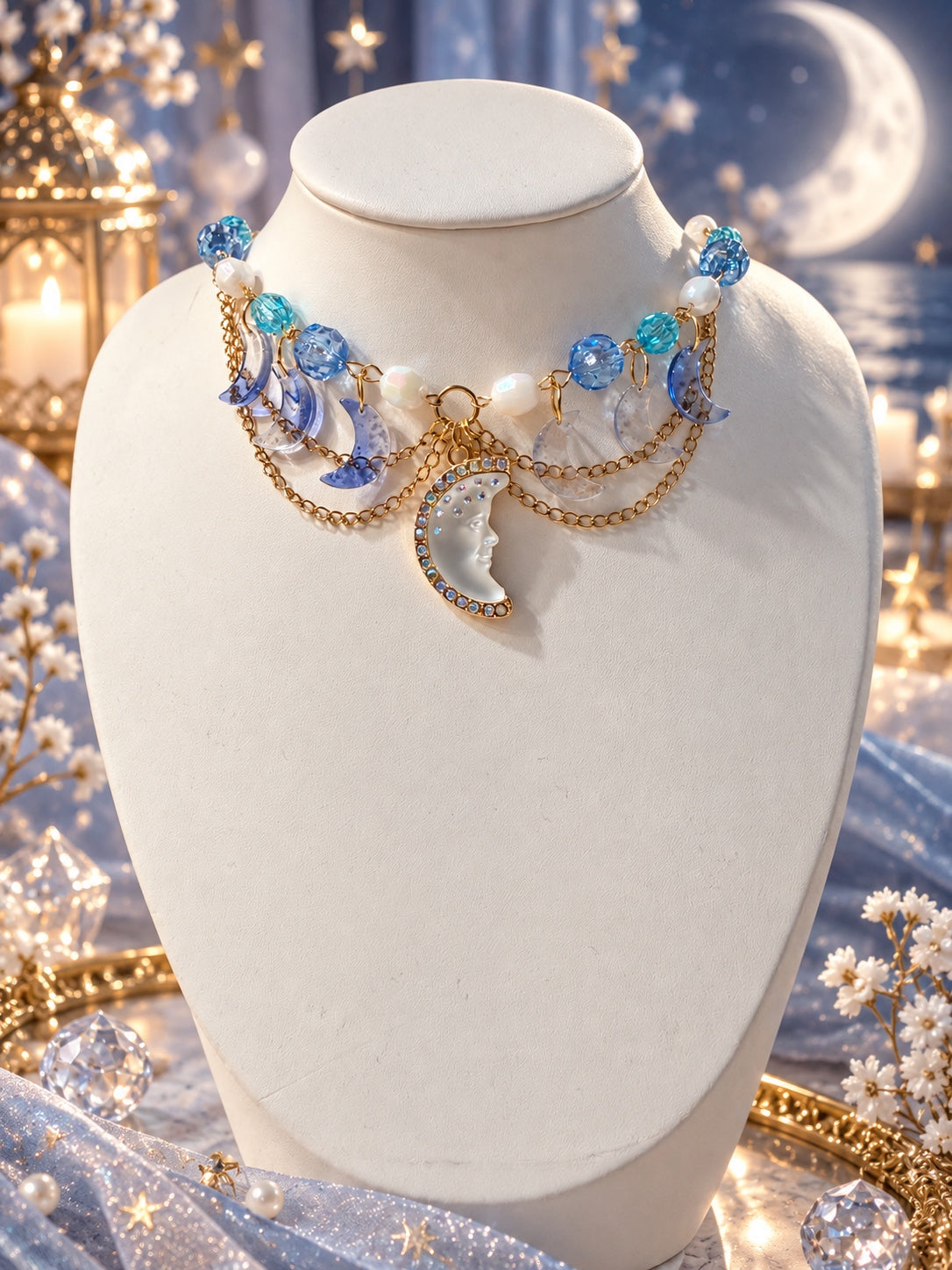 Handmade celestial necklace with blue and white beads, gold-tone chain drapes, crescent moon charms and a moon face centerpiece
