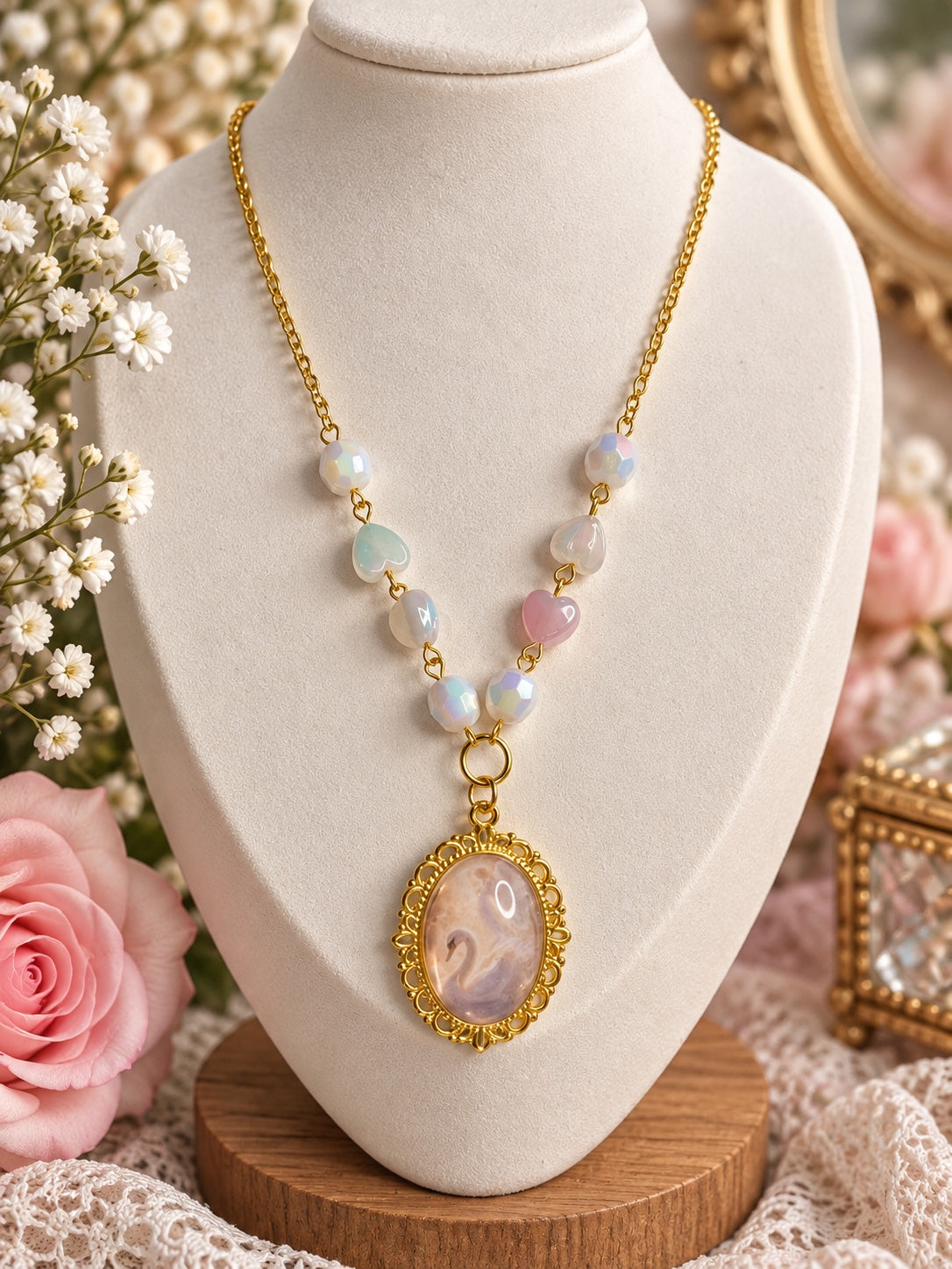 Gold-tone swan cameo necklace with pastel heart beads and iridescent white faceted beads
