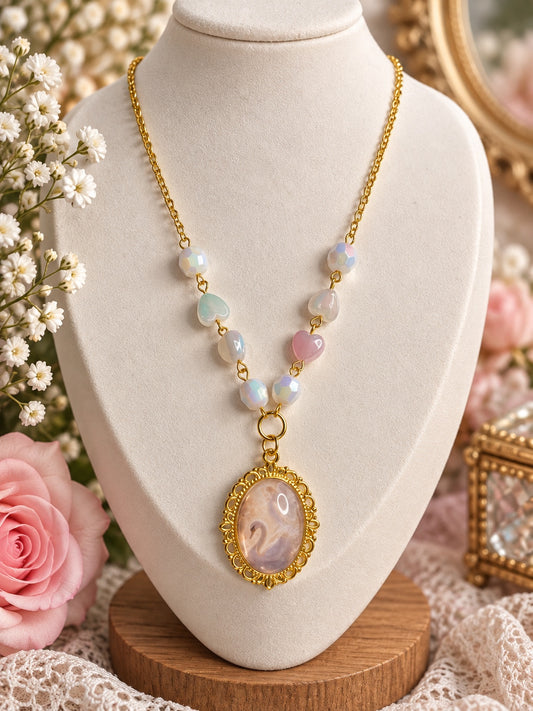 Gold-tone swan cameo necklace with pastel heart beads and iridescent white faceted beads