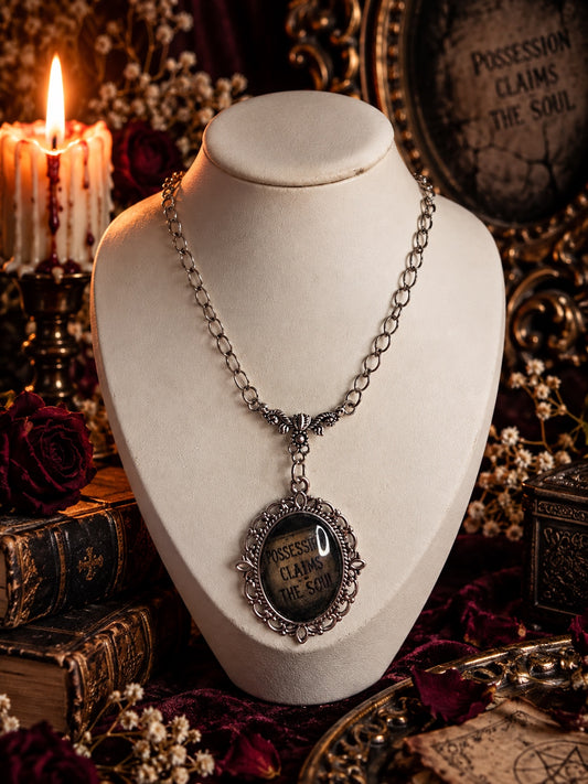 Close view of the silver gothic Possession Claims the Soul necklace.