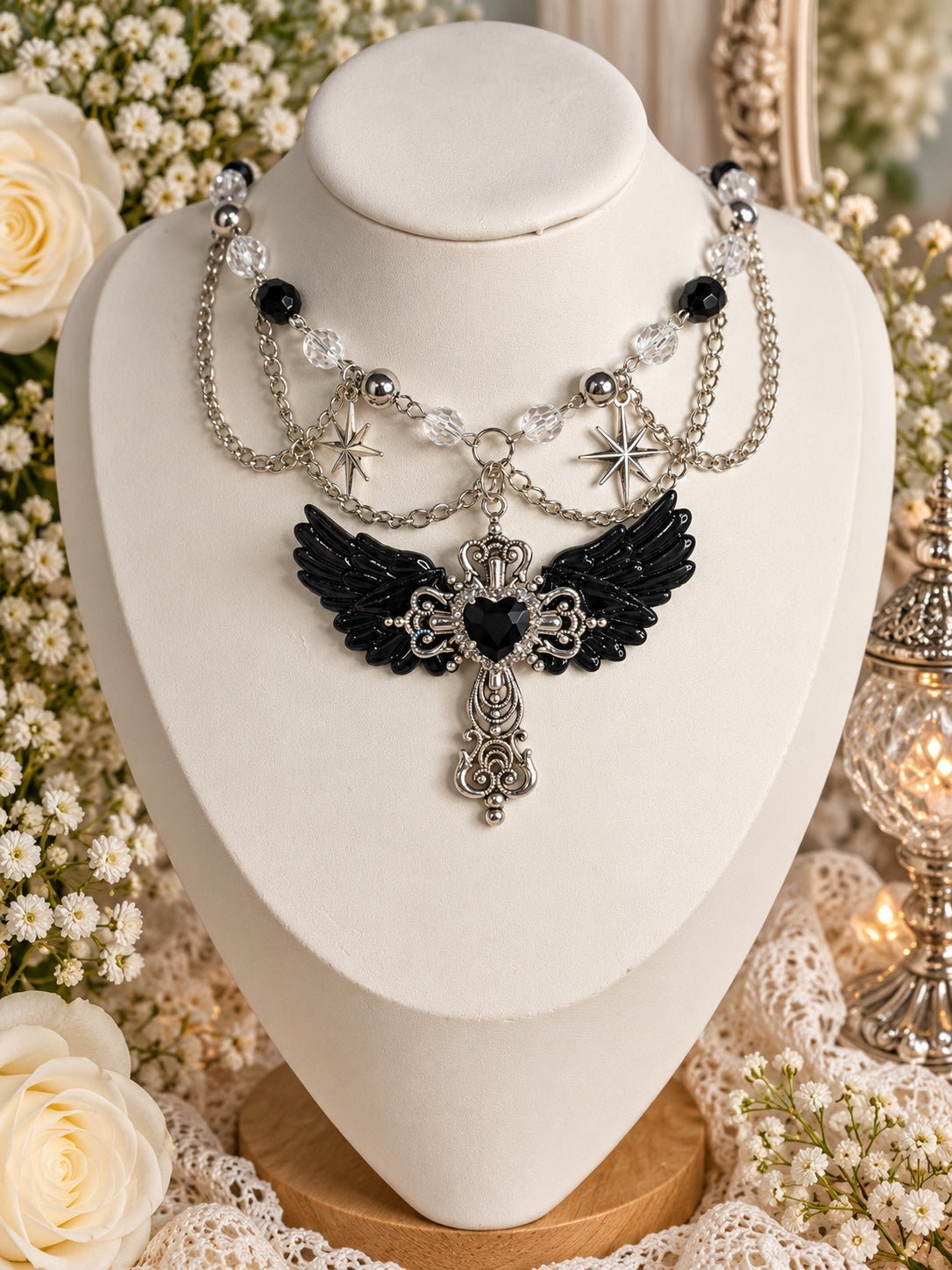 Ravenheart Sanctum Necklace with black wings, an ornate silver-tone cross and black heart, starburst charms and draped chains