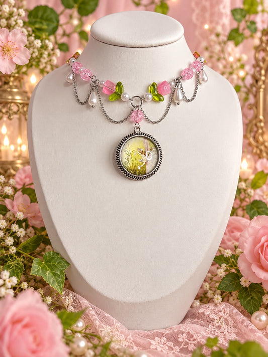 Fairycore necklace with pink flower beads, green leaves, white pearl-style drops, draped silver-tone chains and a round fairy pendant.
