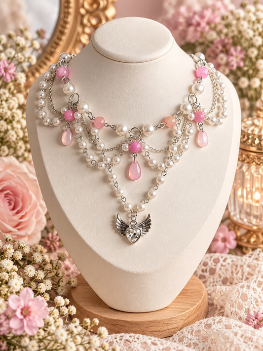 Layered pink and white faux-pearl necklace with silver-tone chains, pink drops and a winged heart pendant