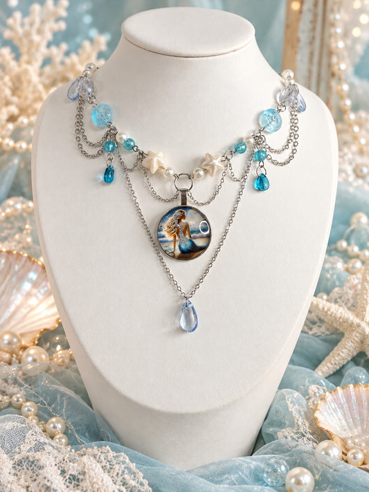 Layered silver-tone mermaid necklace with aqua beads, white faux pearls, star-shaped beads, blue teardrops and a round mermaid portrait pendant