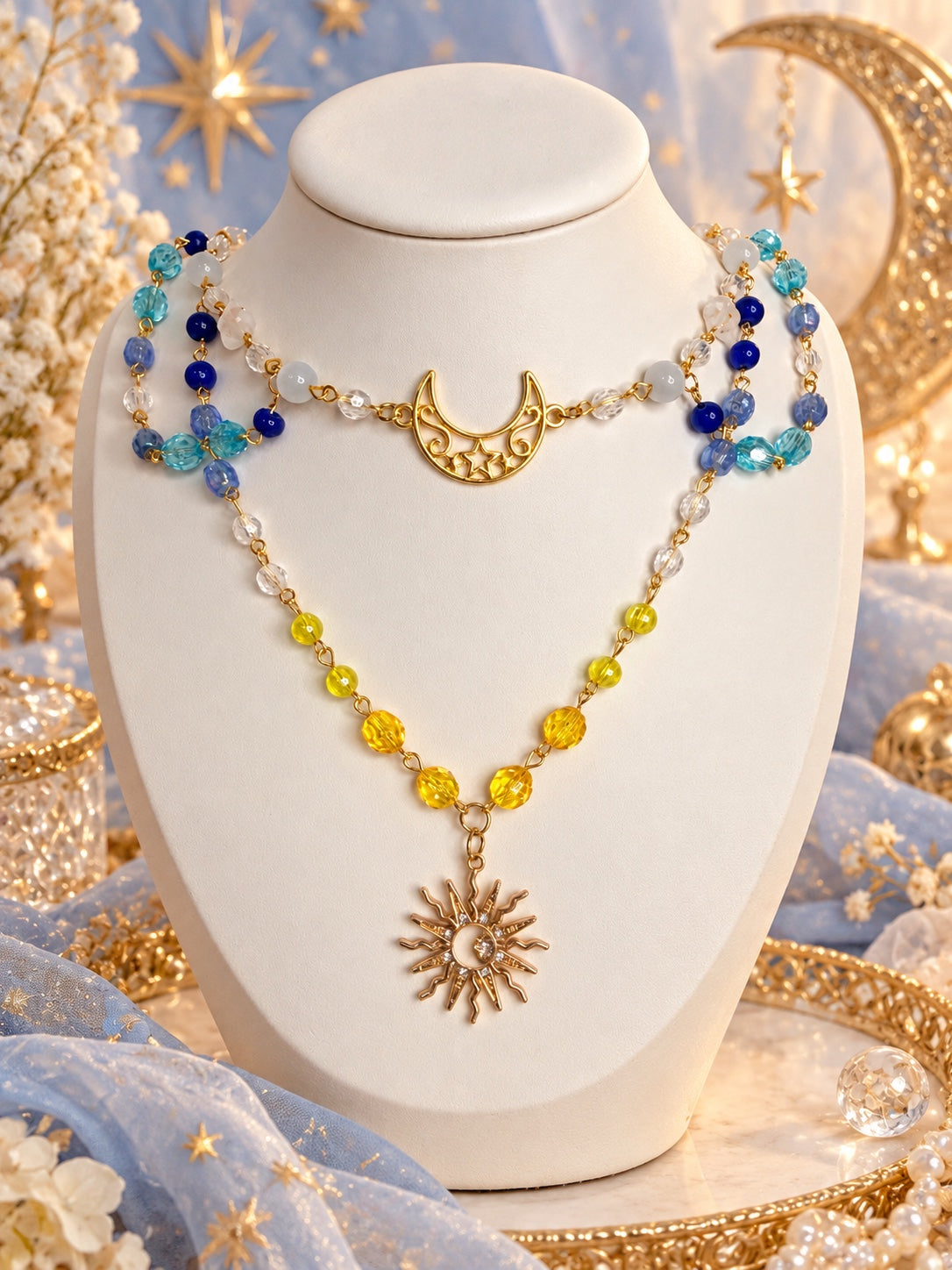 Gold-tone layered celestial necklace with a crescent moon, sun pendant and blue, aqua, white and yellow beads
