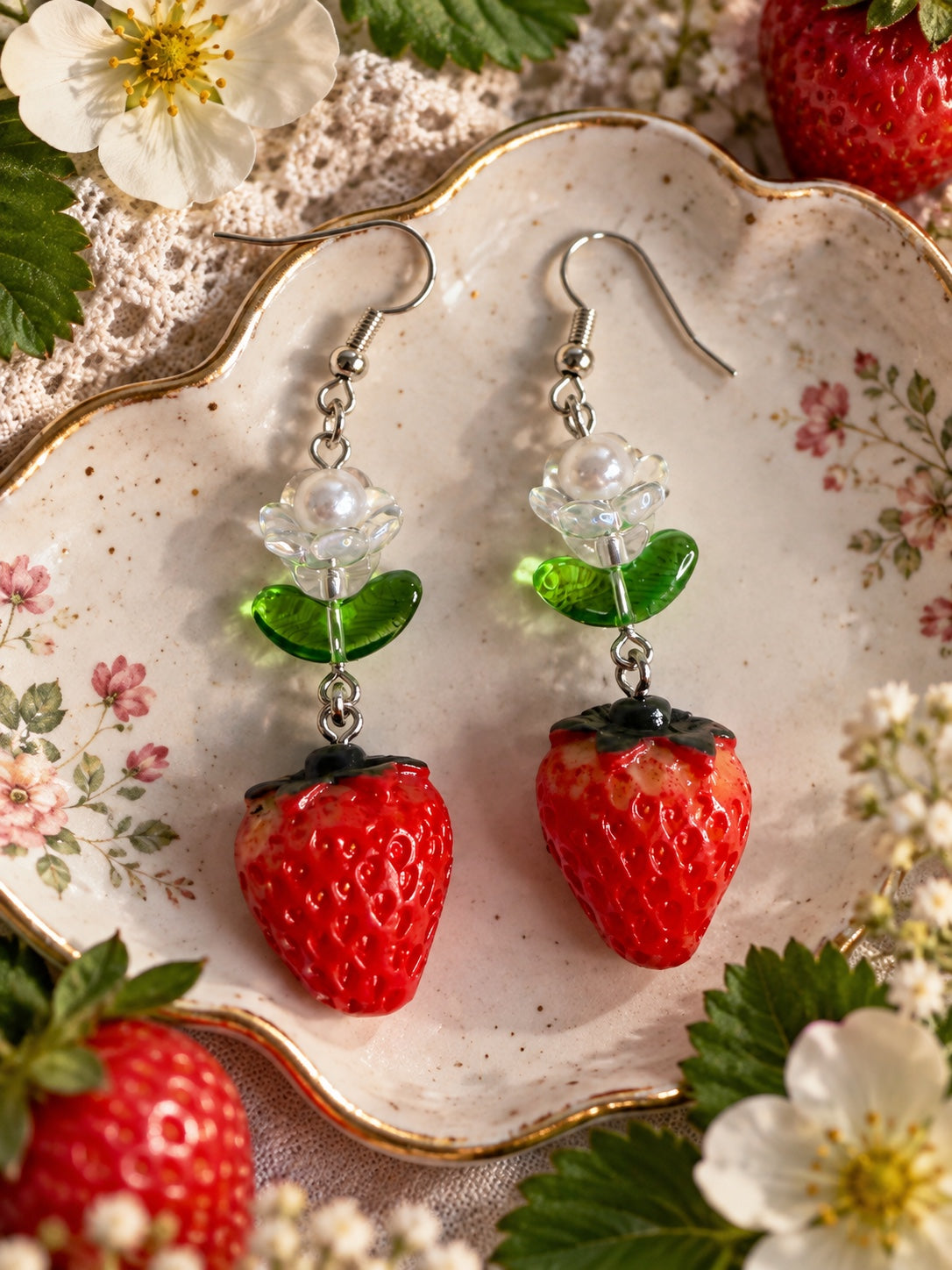 Red strawberry drop earrings with green leaves, translucent flowers, faux pearl centres and silver-tone hooks
