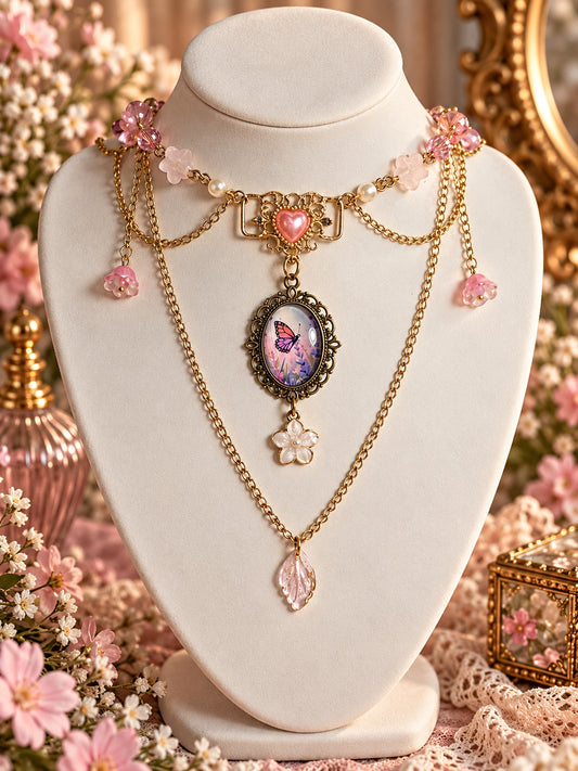 Layered gold-tone necklace with a pink heart, butterfly cameo, pastel flower charms and a pink leaf pendant.