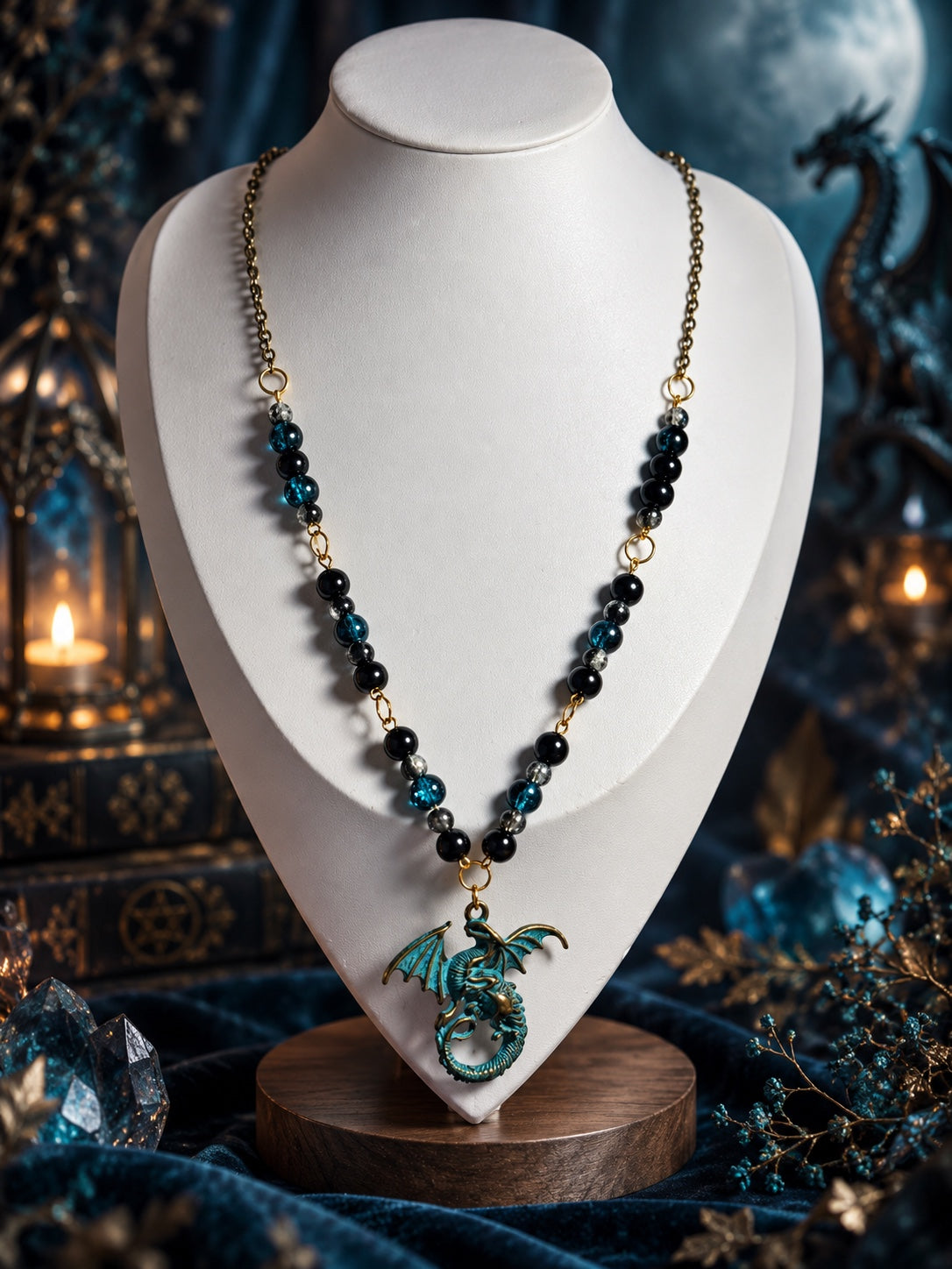 Long necklace with black, teal-blue and smoky beads, an antique gold-tone chain and a turquoise-coloured dragon pendant with spread wings and a curled tail.