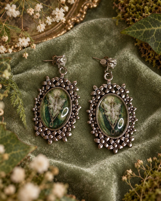 Silver-tone floral oval earrings with green elven-inspired cameo artwork and clear faceted stud tops.