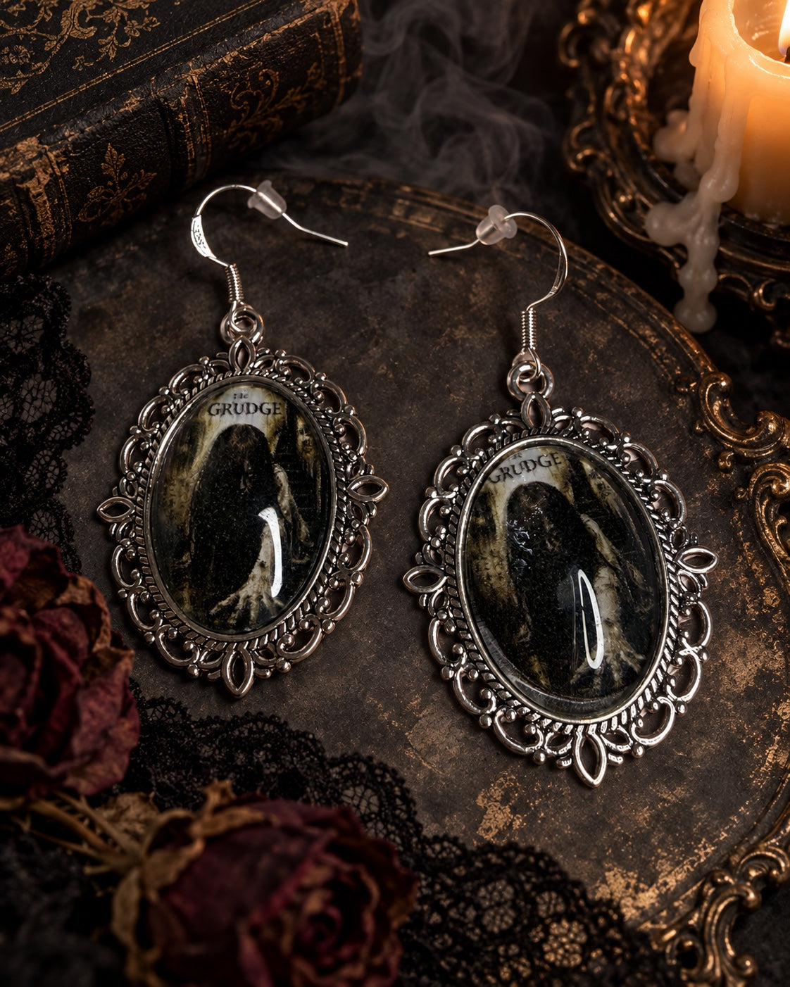 The Grudge portrait earrings in ornate silver-tone oval frames with 925 sterling silver hooks.