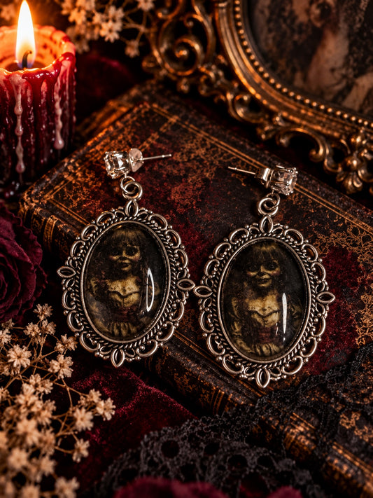 Second view of the Haunted Doll Earrings with oval portrait pendants and silver-tone frames.
