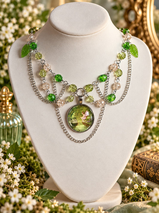 Layered silver-tone necklace with green and clear beads, leaf charms and a round fairy and frog pond pendant.