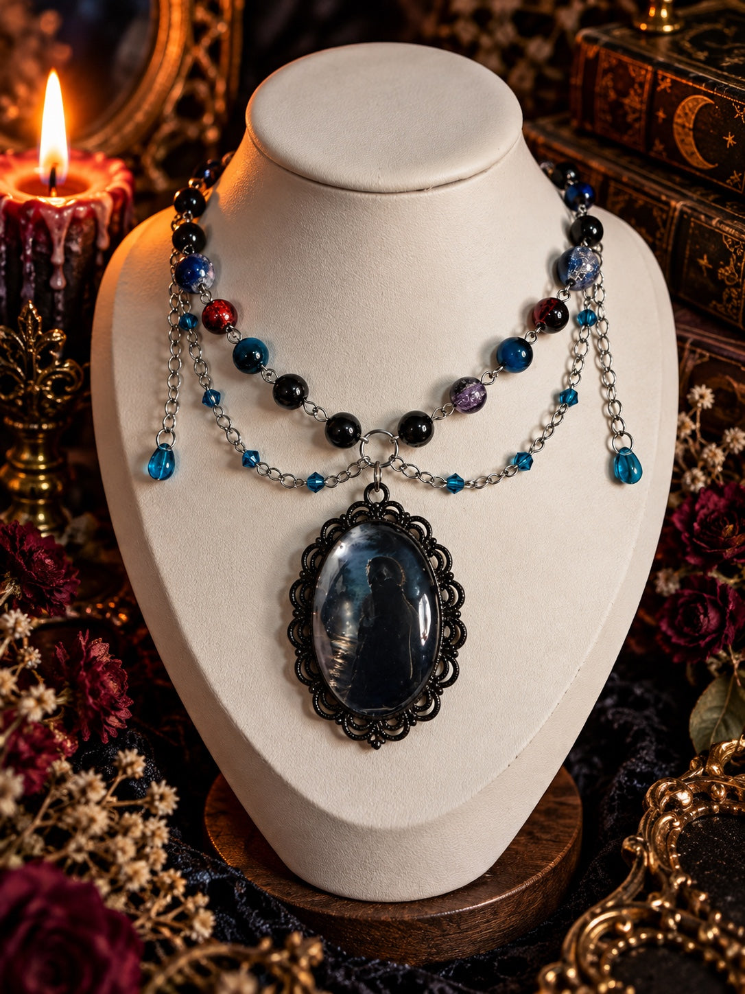 Layered horror necklace with black and blue beads, silver-tone chains, blue drops and an ornate black oval portrait pendant.