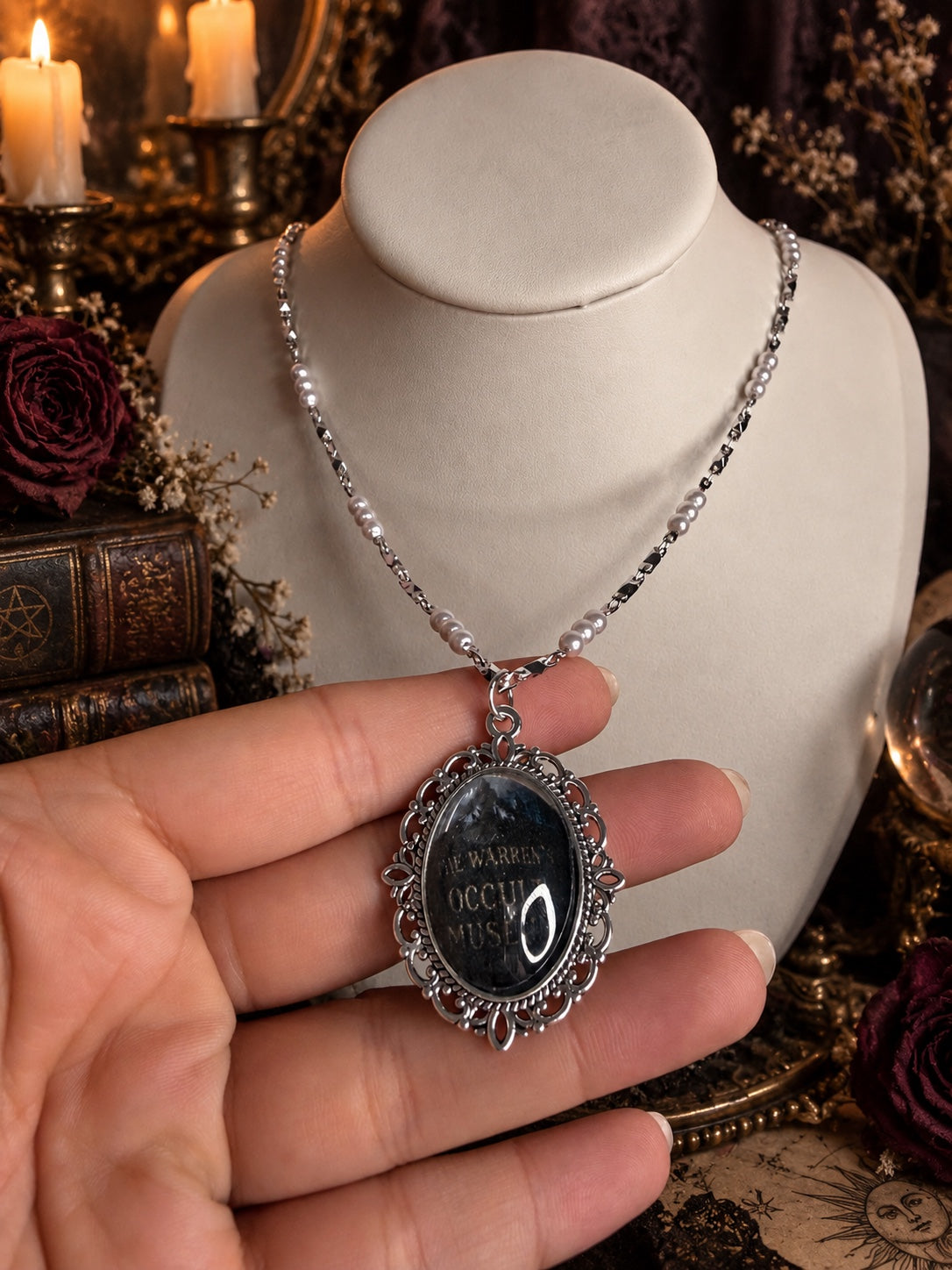 Silver-tone necklace with white pearl-style beads and an ornate oval Warren Occult Museum pendant.