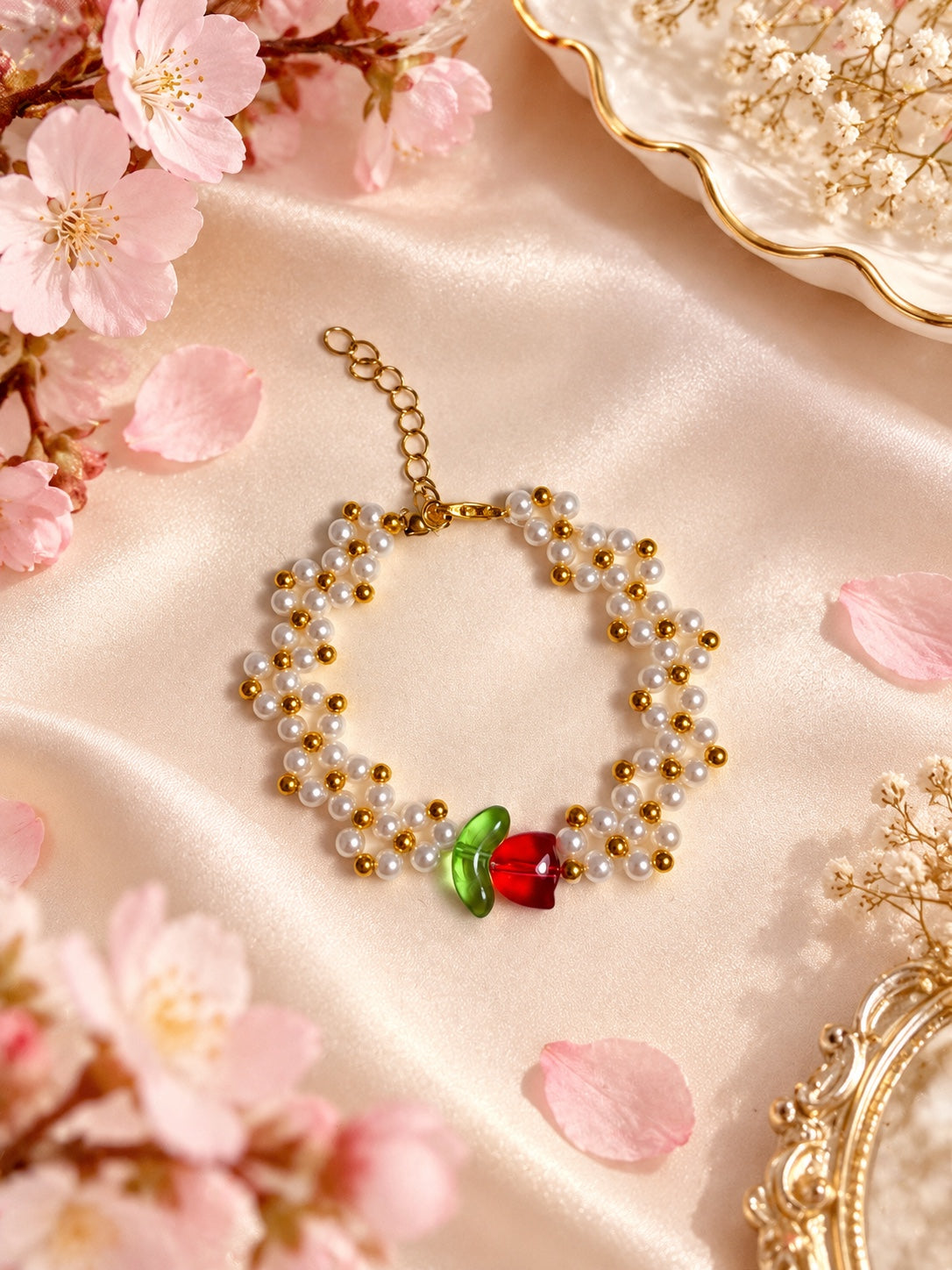 White faux pearl flower bracelet with gold-tone beads, a red tulip and green leaf centrepiece, lobster clasp and extension chain.
