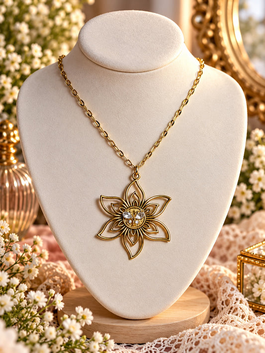 Gold-tone necklace with an openwork six-petal flower pendant and clear sparkling accents at its centre.