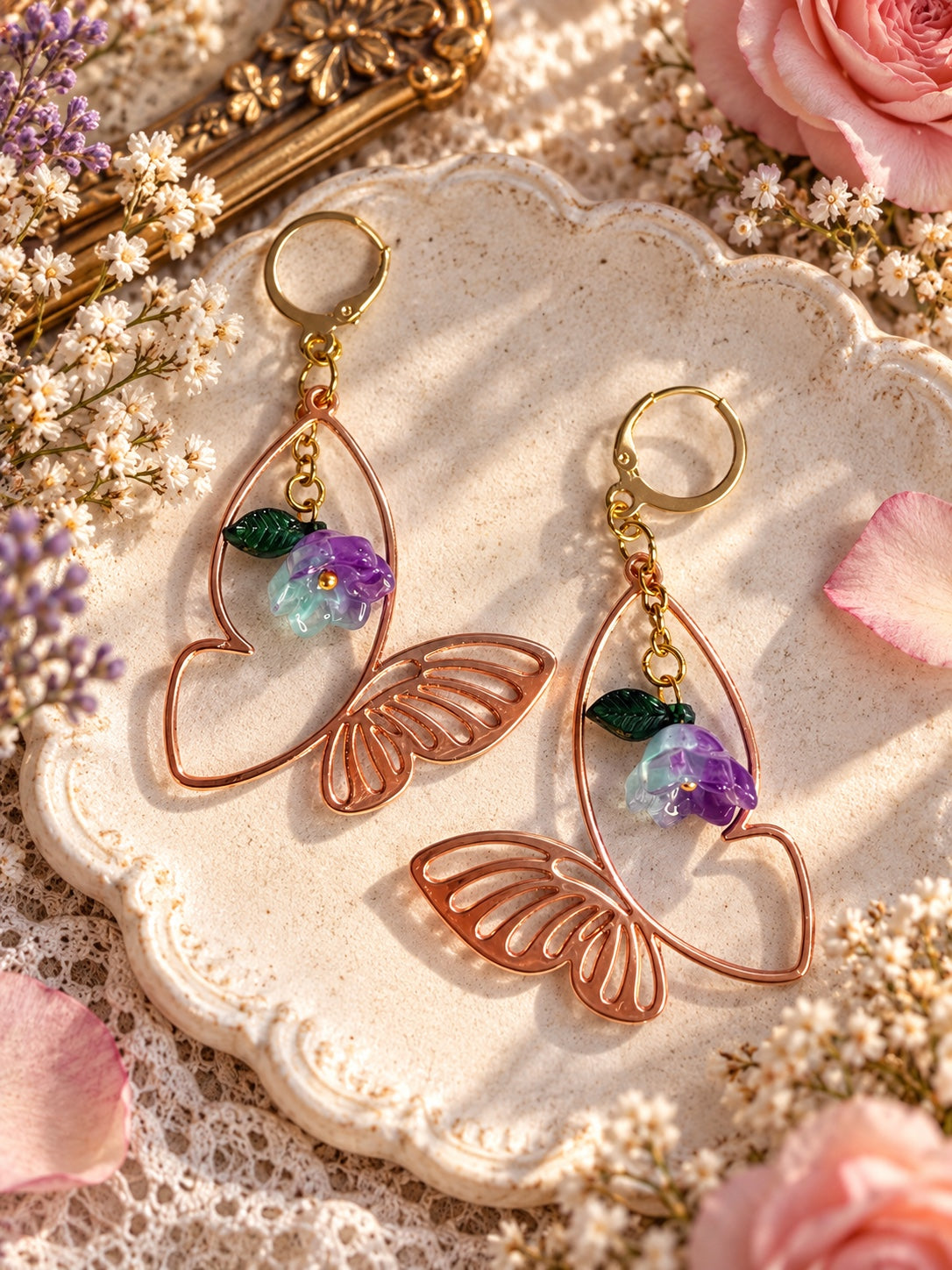 Rose-gold-tone openwork butterfly earrings with purple and pale aqua flowers, green leaves and gold-tone leverbacks