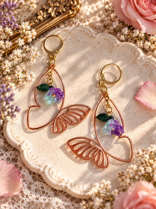 Rose-gold-tone openwork butterfly earrings with purple and pale aqua flowers, green leaves and gold-tone leverbacks