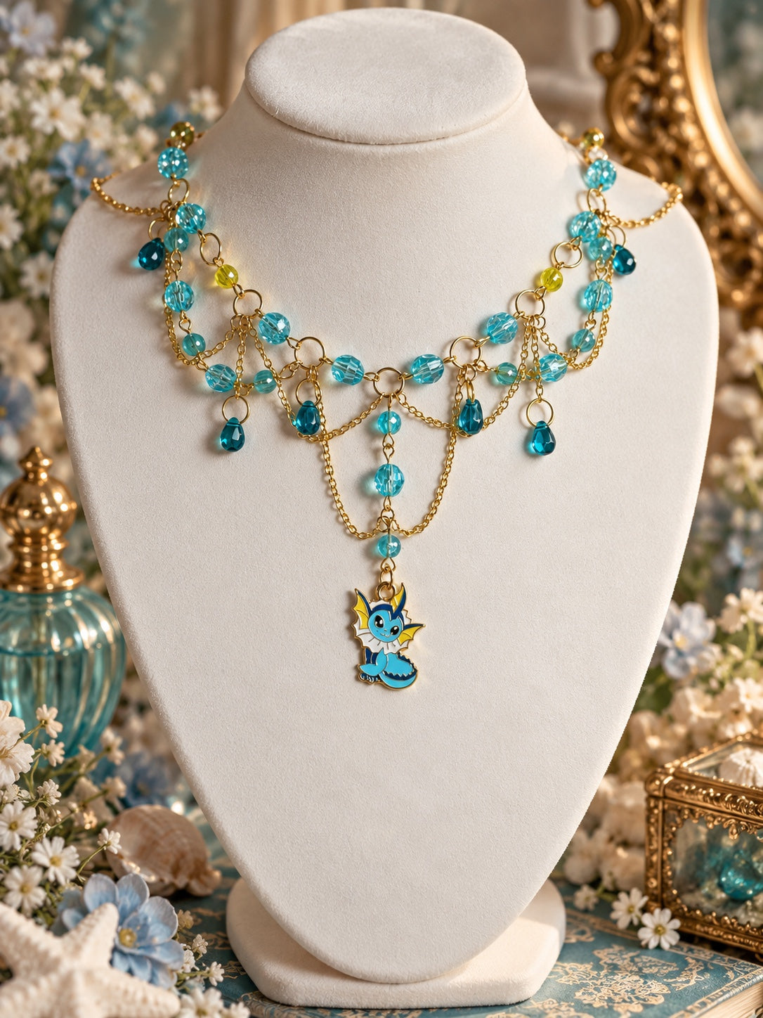 Vaporeon charm necklace with aqua beads, teal teardrops, yellow accents and draped gold-tone chains.