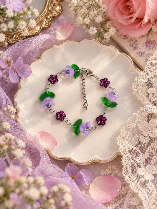 Silver-tone bracelet with lilac bell flowers, translucent green leaves and dark purple flower beads